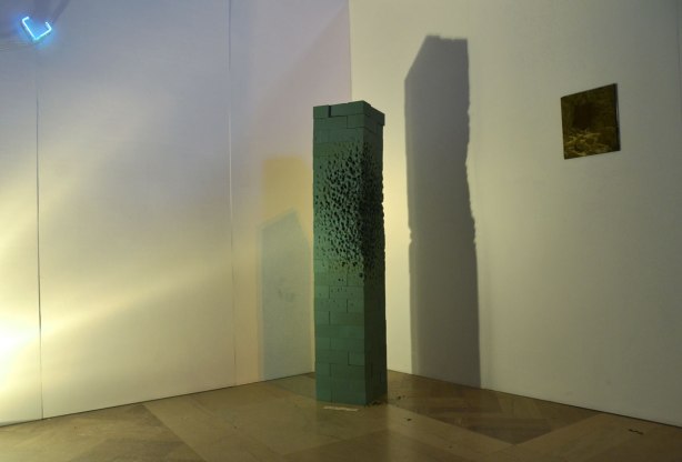 A corner of a dimly lit white walled room. In the