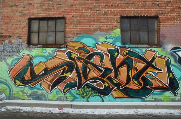 colorful graffiti tags on a brick wall