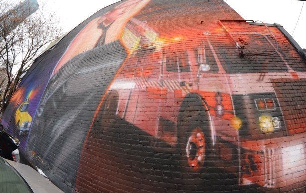 right hand side of the bathhouse raid mural on Church St. showing a firetruck with its red flashing lights on