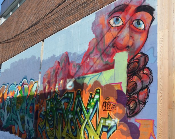 A large pinkish man's face, with big blue eys, and large hands