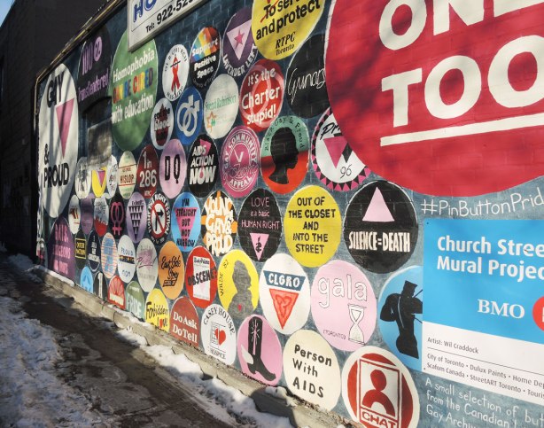 Close up of part of a mural that is circular buttons from the gay and lesbian community with slogans and sayings on them. 