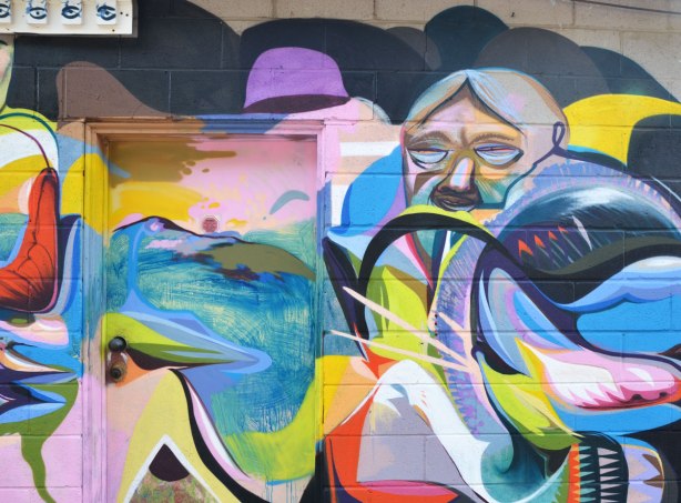 colourful graffiti painting of a man's face surrounded by a lot of abstract shapes