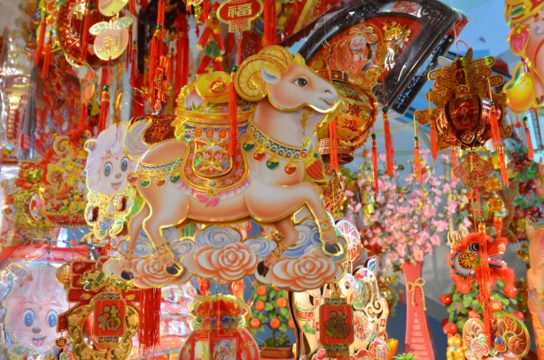 hanging paper decorations for Chinese New Year in bright colours and featuring ram and sheep shapes. 