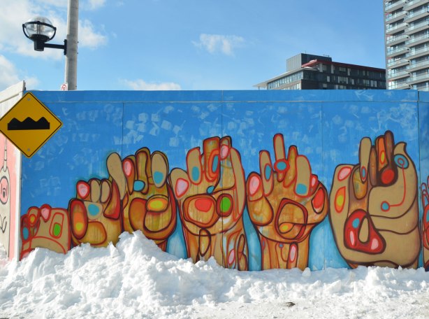 Street art of six stylized hands on a blue background.