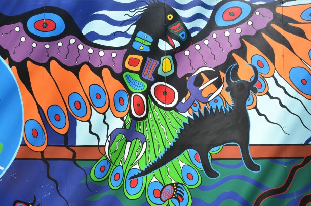part of an Anishnawbe First Nations story/legend themed mural painted on wood construction hoardings in Allan Gardens - a stylized eagle in bright colours in flight. 