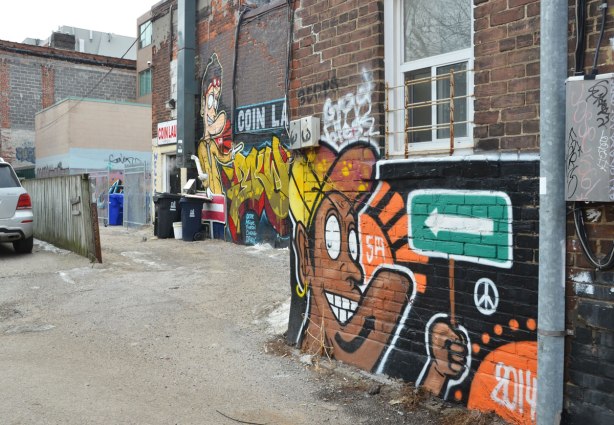 street art in a lane, view looking down the lane.