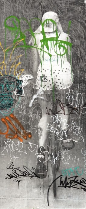 Close up of picture of woman riding away on a bicycle. An I love Toronto CN TOwer personification sticker is also in the picture