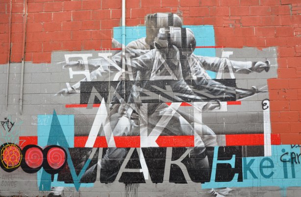 mural of a fencer with sword drawn and ready. The words are "Make it". It is slightly abstracted and painted to look like there is motion in the picture.