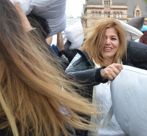 Two women in a pillow fight, lots of long hair blowing and being thrown around. 