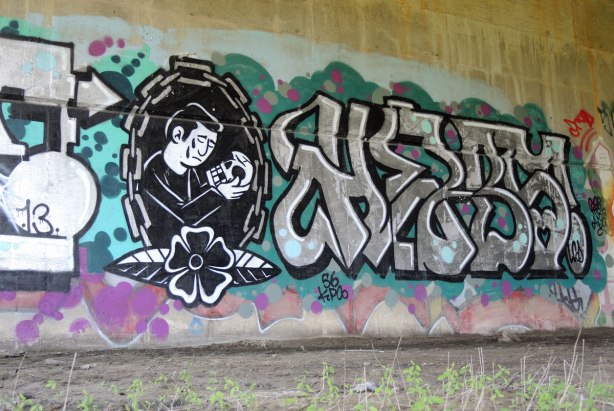 street art - a memorial in greys, a man with a tear on his cheek is holding a skull