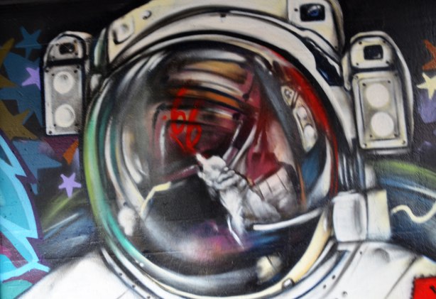 street art painting under a railway bridge - astronaut's helmet