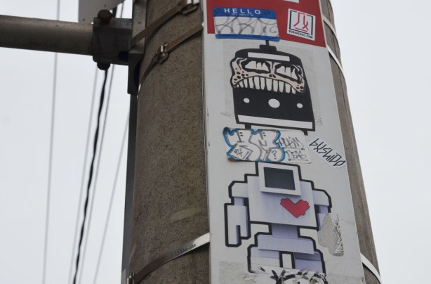a lovebot sticker on a TTC bus stop pole