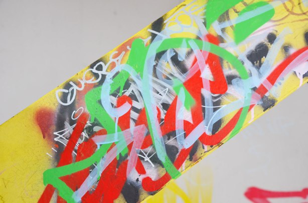 yellow metal girder covered with scribbles in black, red, and green.