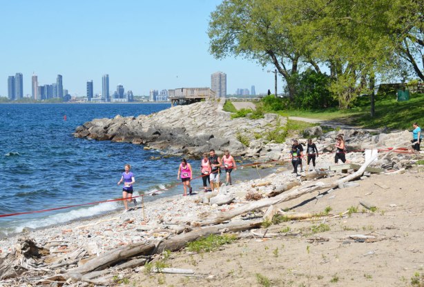 runners on the beach with the Mississauga skyline in the distance