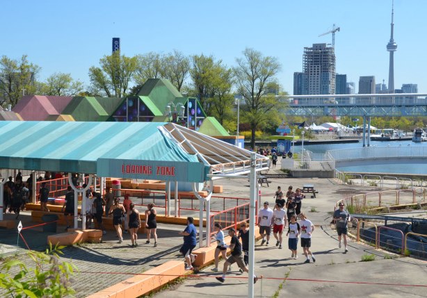 runners in a race around Ontario Place go through the old "loading zone" area.  Toronto skyline and CN tower in the background. 