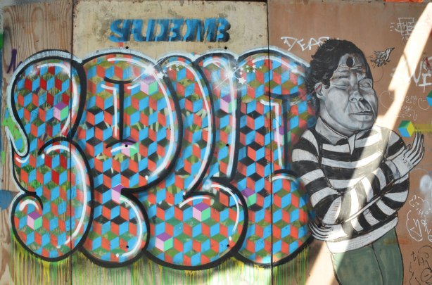 street art under a railway underpass - tag spud and stencil that says spudbomb