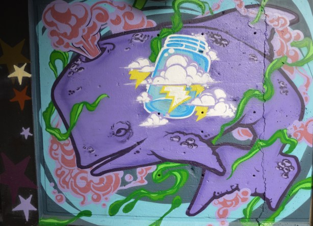 street art painting under a railway bridge - purple whale 
