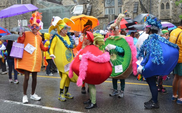 A group of men dressed up as different fruits, banana, kiwi, blueberry, apple and orange