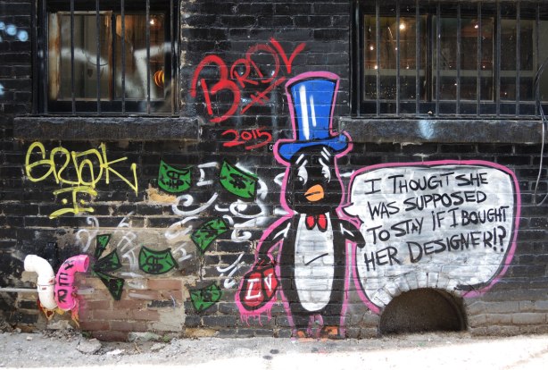 graffiti and street art in Graffiti Alley in Toronto - BRDL, Penguin looking worried, dollar bills are flying out of his pockets and into a (real) vent of the building.  He's wearing a blue tophat.  Word bubble says 