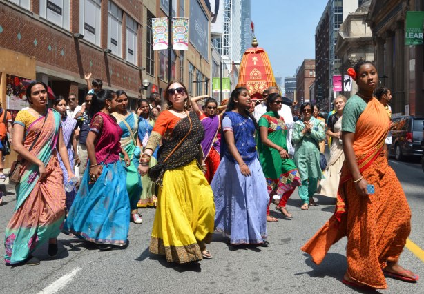 Some women in saris and men in traditional Indian clothes, dance and walk in a parade down Yonge St. as part of the Festival of India