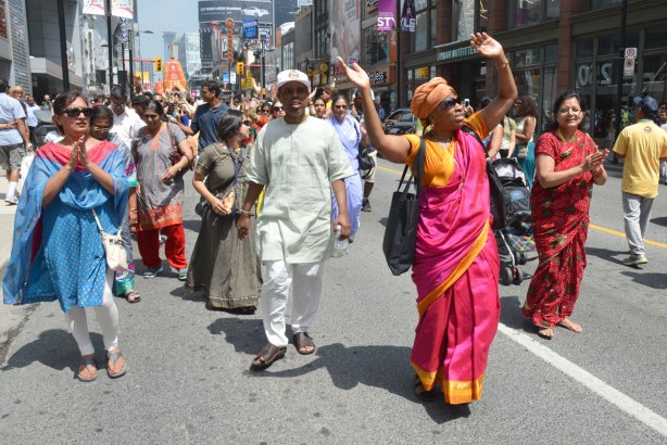 Some women in saris and men in traditional Indian clothes, dance and walk in a parade down Yonge St. as part of the Festival of India 
