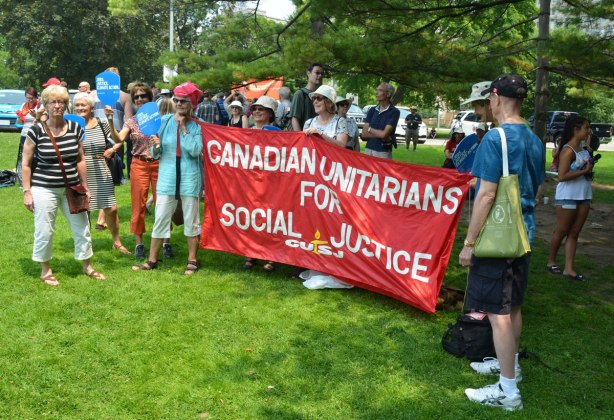 A group of people holding a large red banner that says 'Canadian Unitarians for social justice'