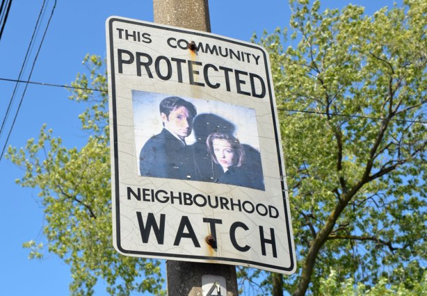 An altered Neighbourhood Watch sign. A man and a woman, agents Mulder and Scully from the TV series X Files