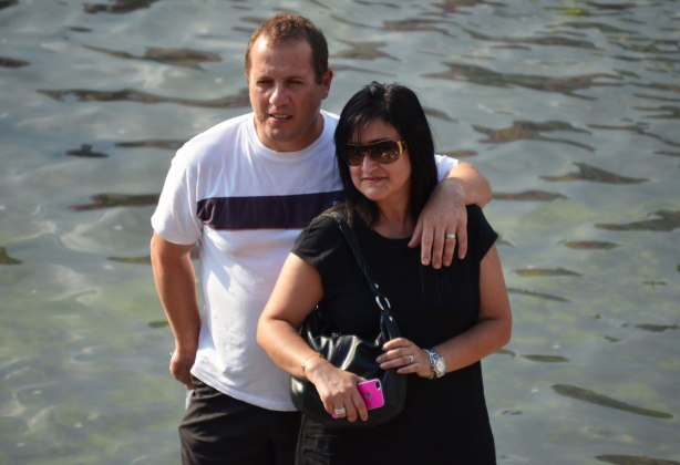 A couple poses beside the water in Nathan Phillips Square. 
