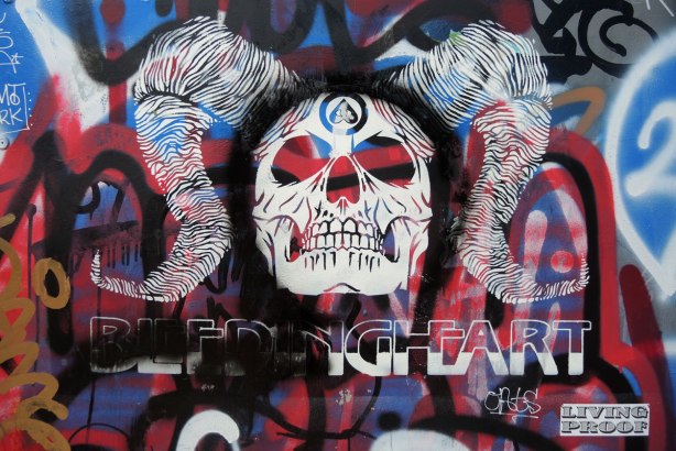 A white graffiti skull with the words belleding heart written underneath