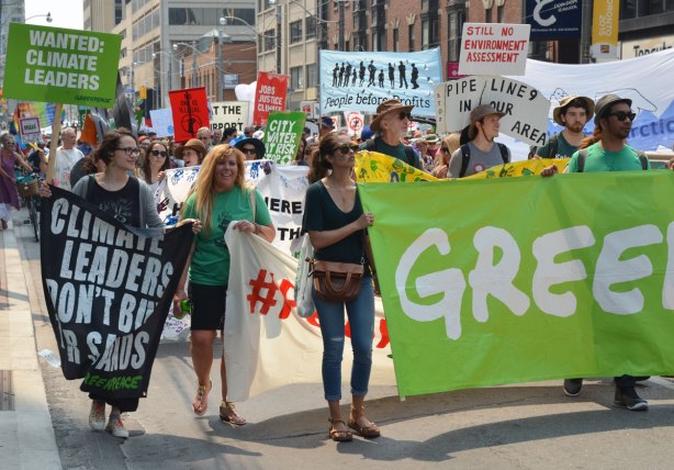 A large number of people walking in a protest march carrying signs and banners