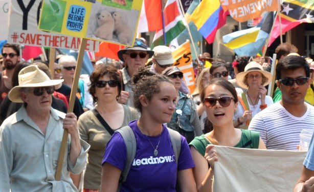 A diverse group of people walk in a protest march in Toronto