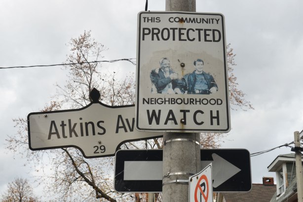 Neighbourhood watch sign by Atkins Ave.., picture of Mel Gibson and Danny Glover has been pasted on it, two actors from Lethal Weapons movies.