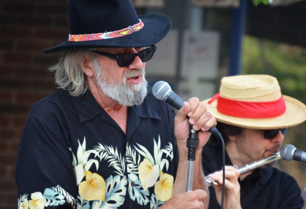 lead singer for Blue Room, grey hair and beard, Hawaiian shirt, black hat, singing at streetfest at the beach