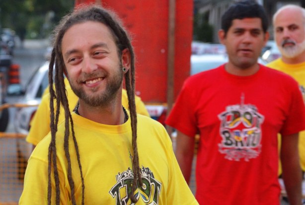 young man in dreadlocks and a yellow Tshirt waiting to perform at a music festival 