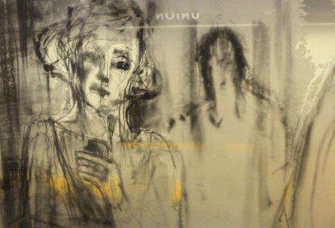 black and white painting on glass of a woman holding a mobile phone