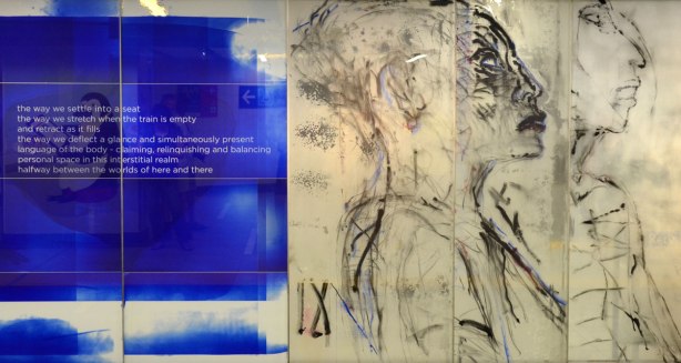 part of an art installation, paintings on glass panels, on the left are white words on blue background, on the right are two women in profile