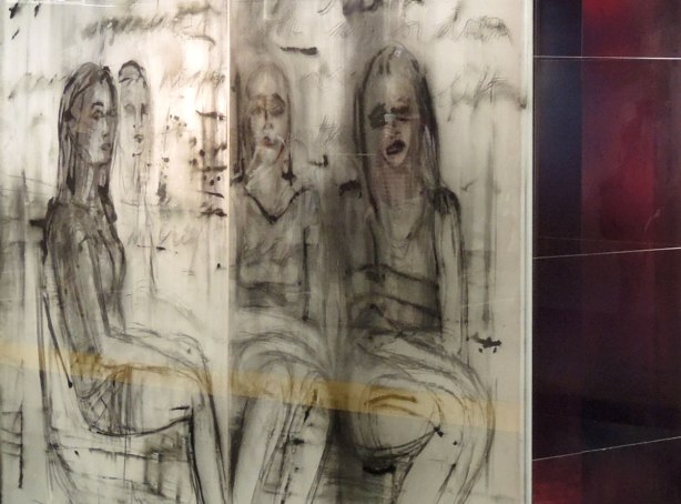 part of an art installation, paintings on glass panels, four women sitting on the subway 