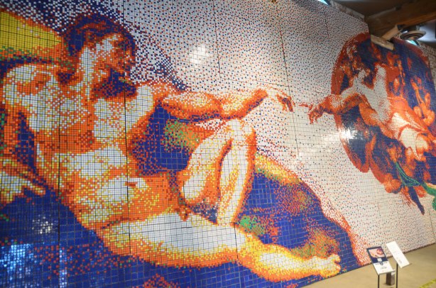 A copy of Michaelangelo's painting on the Sistine Chapel ceiling, The Creation of Adam where God is giving life to man with the meeting of finger tips.