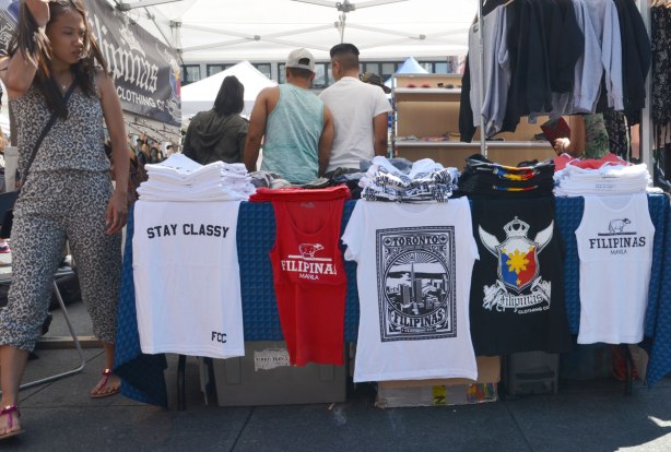 a line of filipino design T-shirts for sale on a table outdoors