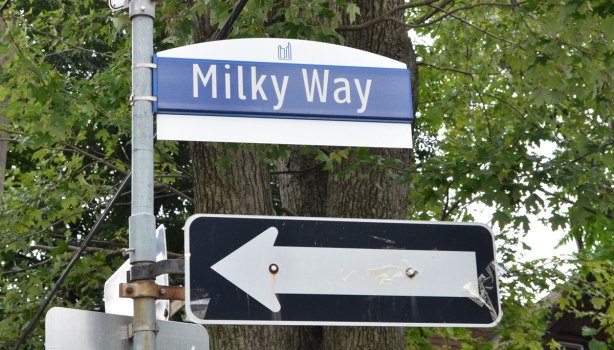 Toronto street sign, Milky Way, with a one way arrow sign below it. 