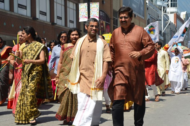 Men and women in a parade to mark India's 69th year of independence. The women are wearing saris and the men are wearing traditional Indian clothes