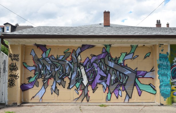 tag like street art on a garage door in an alley crsy fario, killa wales, lpk 66, 