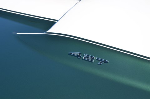 part of the hood of a green and white car with the number 427 on it