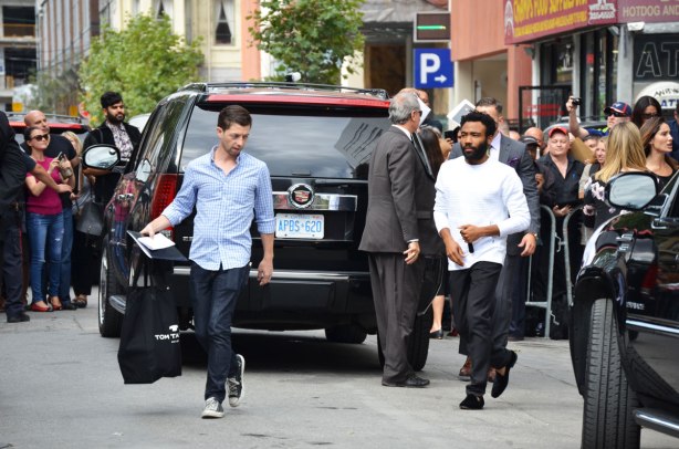 actor Danny Glover being directed towards a car. 