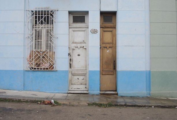 picture taken in the old part of the city of Havana Cuba - two tall skinny doors at number 1106, also a window with metal bars over it. 