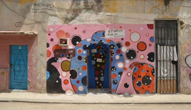 picture taken in the old part of the city of Havana Cuba - the exterior walls and doorway of an artist's studio have been painted blue and pink, with large red, white and black, polka dots. 