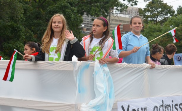 Three girls riding on a float in the Jesus in the CIty parade. 