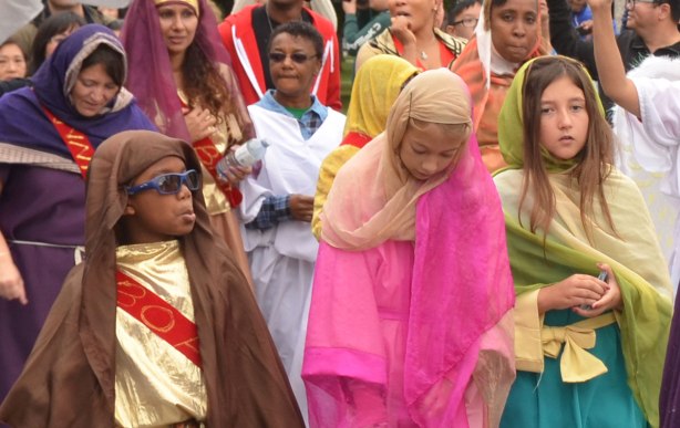 Kids dressed up in colourful costumes and walking in a parade