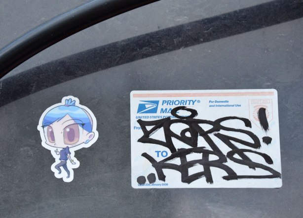 A small sticker of a girl with a large head and big eyes 