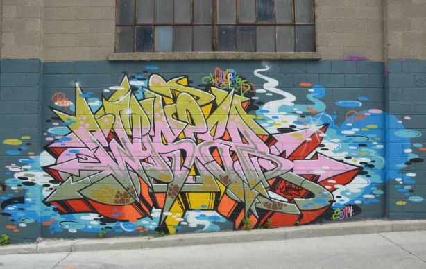 tag-like street art under a window in an alley